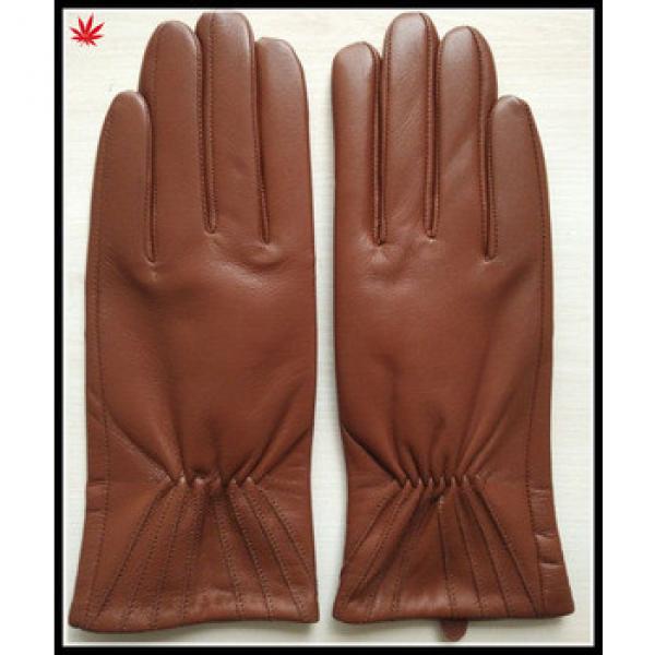 brown genuine leather hand gloves women putting on leather glove #1 image
